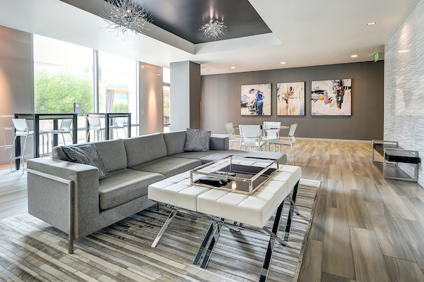 Club room with couch facing away from floor-to-ceiling windows.