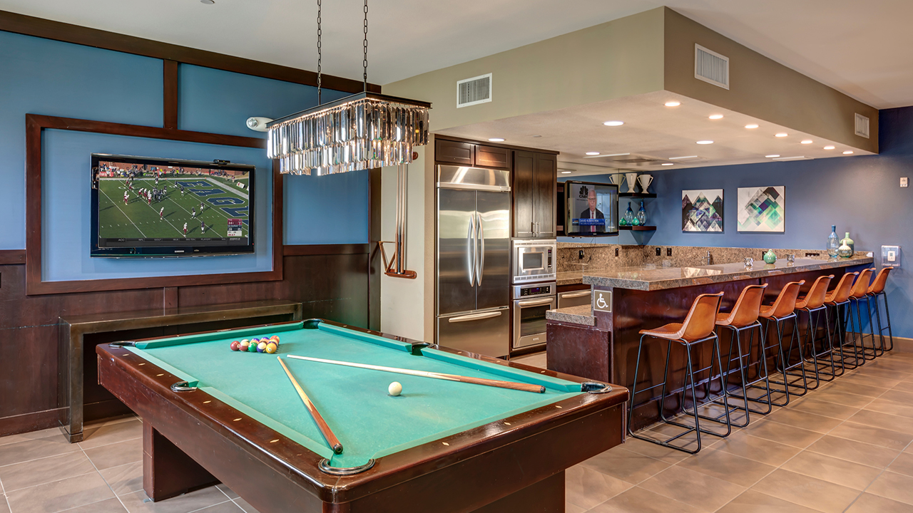 Game Room with a pool table and TV next to kitchen with stainless steel appliances and a breakfast bar