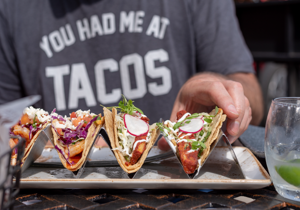 Man displaying four tacos from Ventura