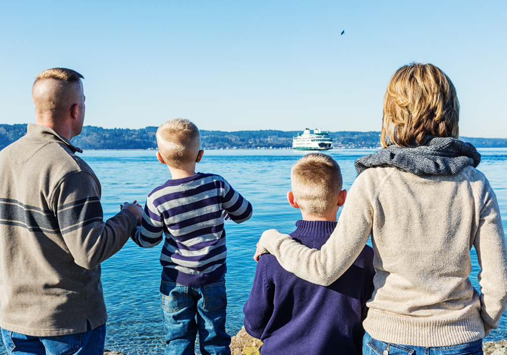 A family of 4 looking out at a lake in Seattle.