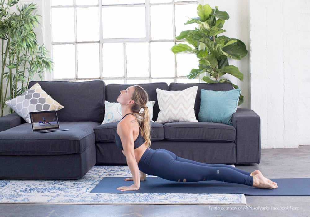 Woman doing a yoga stretch in her apartment home.