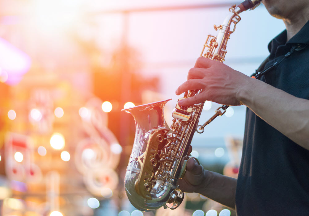 Man playing saxophone at festival.