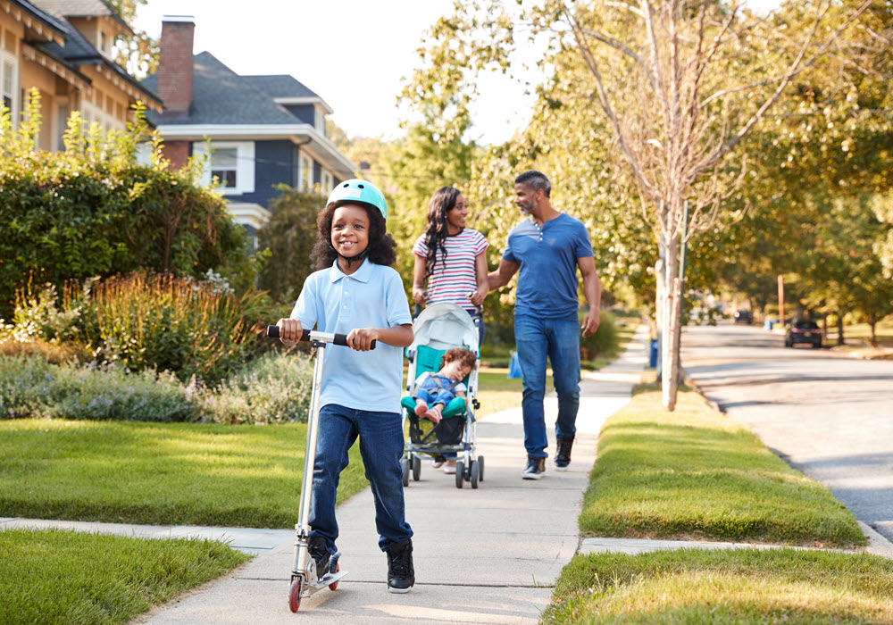 Family of four strolling down a neighborhood.