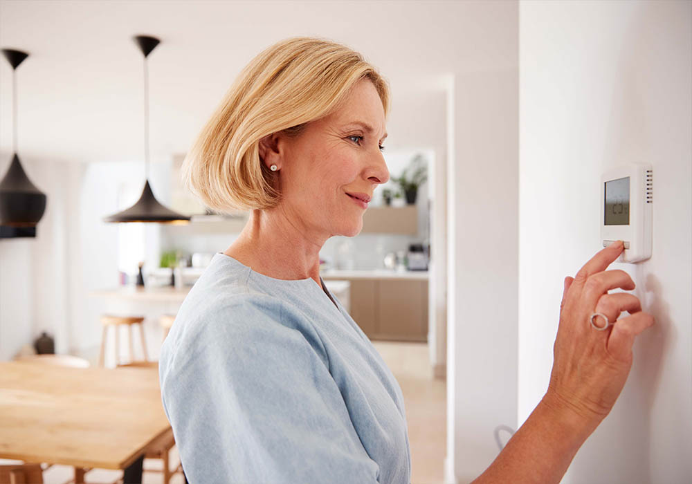 Woman Changing Smart Home Thermostat 