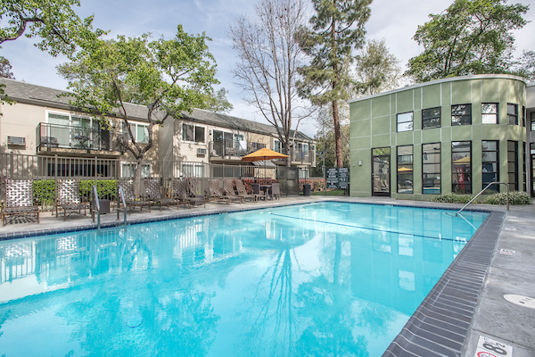 Outdoor swimming pool area with sundeck and lounge seating.