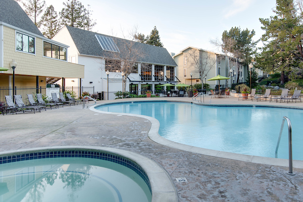Outdoor spa and swimming pool area with sundeck and lounge seating.