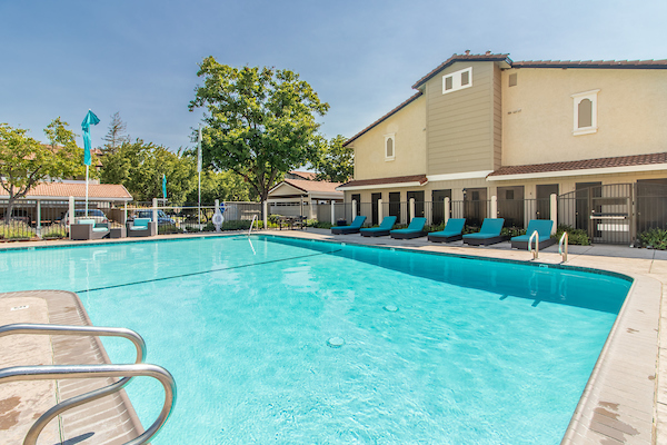 Outdoor swimming pool surrounded by lounge chairs.