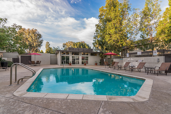 Outdoor swimming pool area with lounge seating and umbrellas.