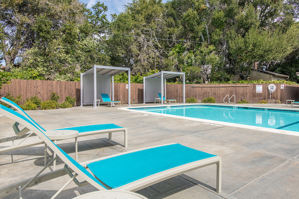 Outdoor swimming pool surrounded by lounge chairs.