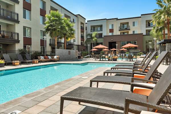Outdoor swimming pool area with sundeck and lounge seating.