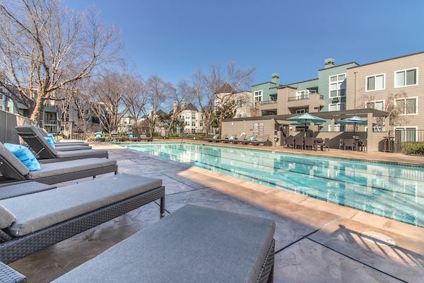 Outdoor swimming pool area with sundeck and lounge seating.