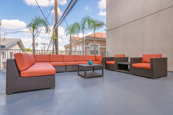 Community courtyard with a table, lounge seating, and a neighborhood view from balcony.