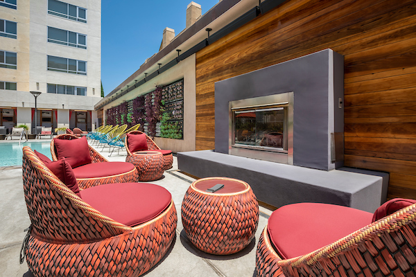 Swimming pool area with outdoor fireplace and comfortable seating.