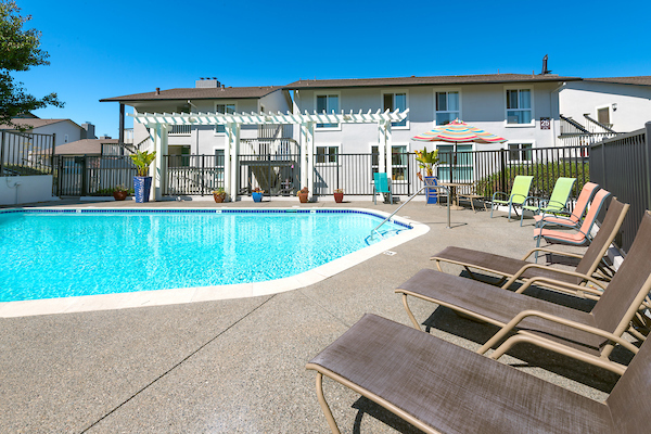 Outdoor swimming pool area with lounge seating and pergola.