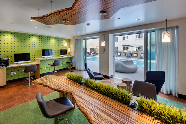 Club room with computers, chairs, and sliding glass doors leading to outdoor swimming pool area.