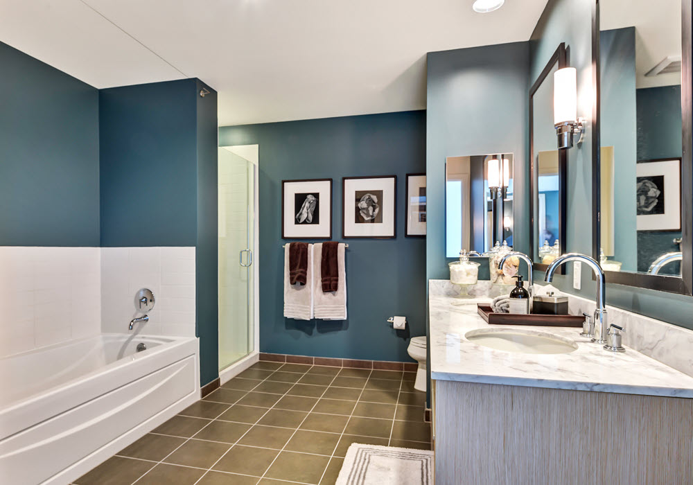 Staged apartment bathroom with teal accent walls.